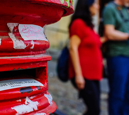 Image of two people standing beside a postbox